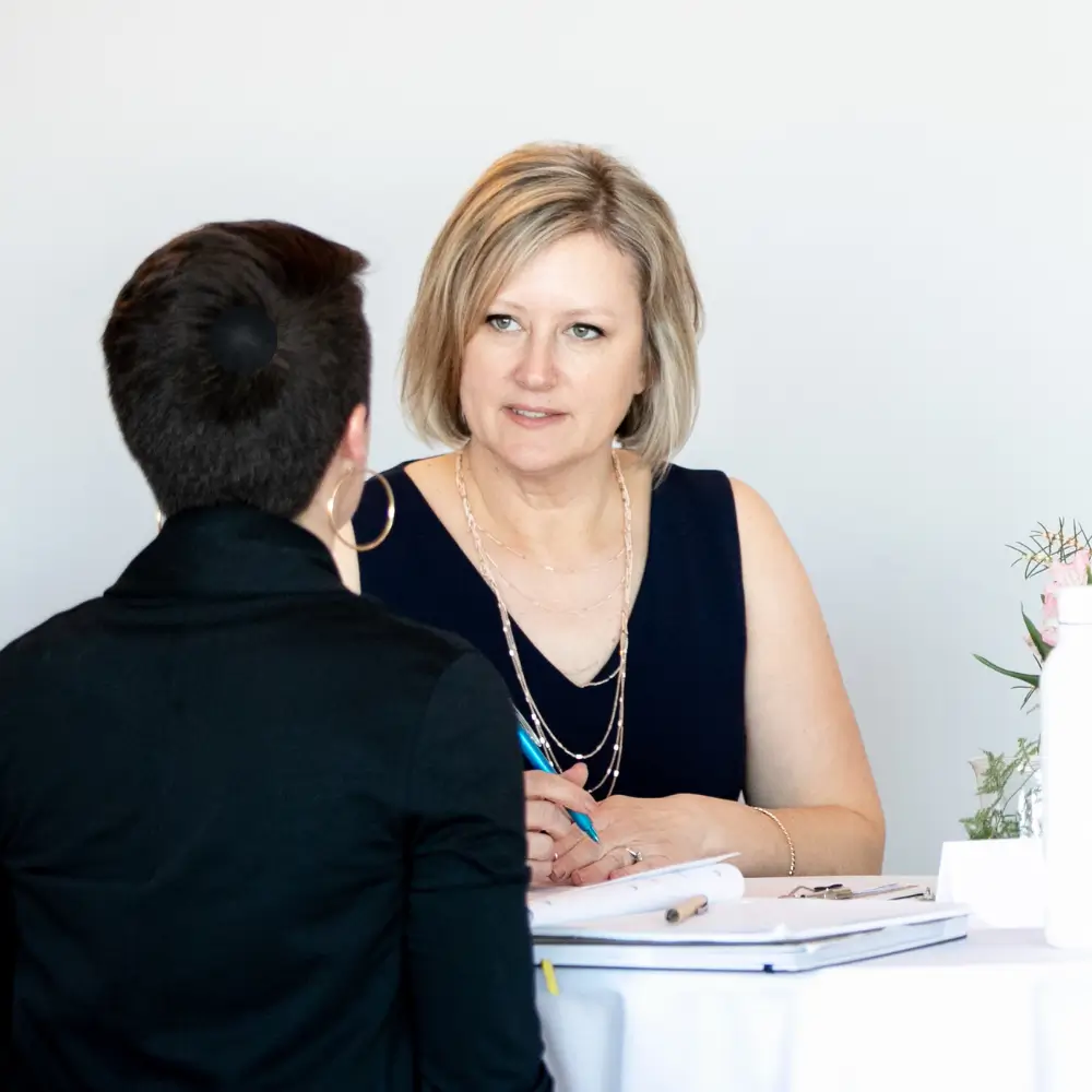 Robin sitting at a table coaching her business client.